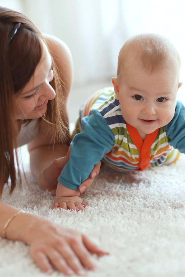 mother and baby crawling on carpet